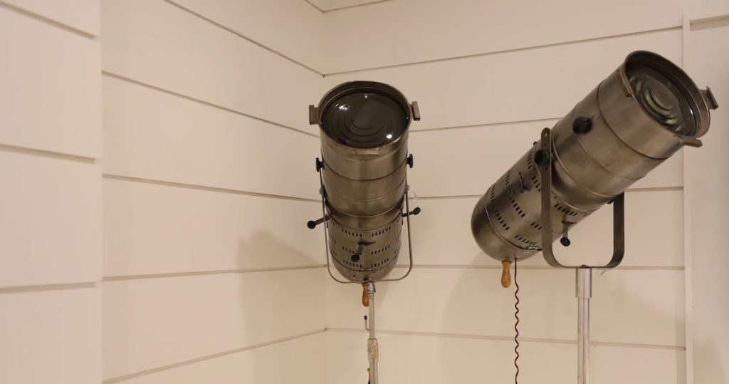 Silver light stands in front of a white shiplap wall at Roam Perimeter Center