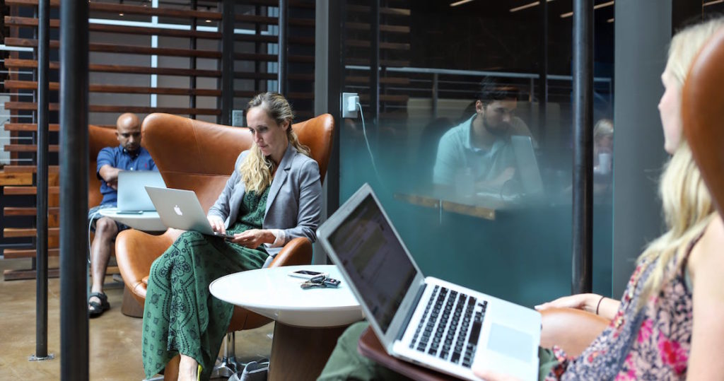Woman holding laptop in coworking space