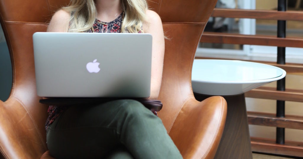Woman working on Macbook in chair