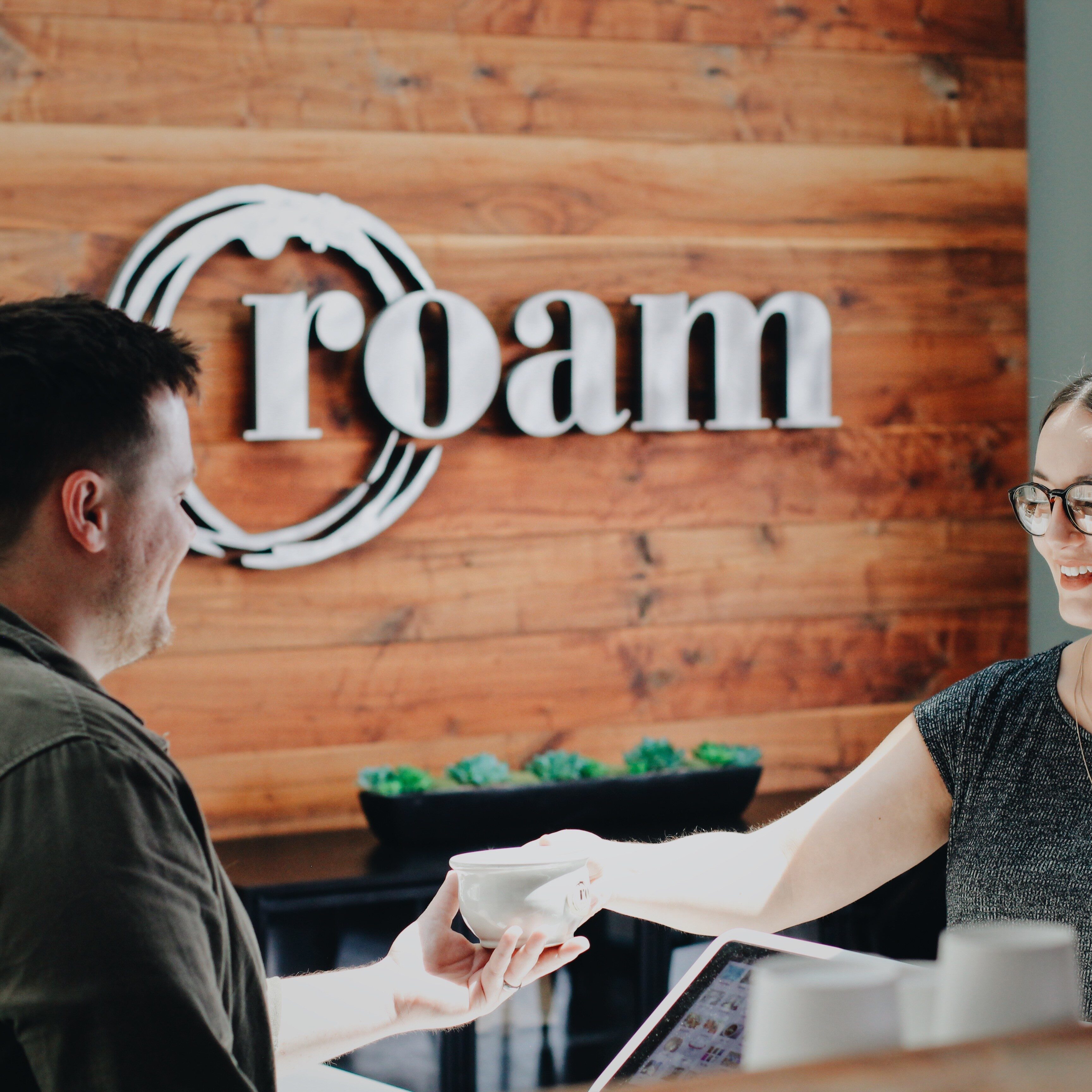 Employee serving coffee at Roam
